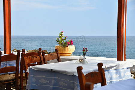 希腊小酒馆和大海中的一张有盖桌子。