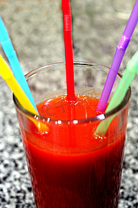 一杯带有多色小管的番茄汁