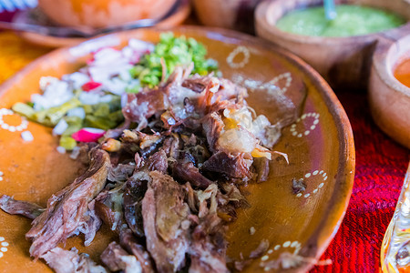 粘土碗中的墨西哥碎羊肉、辣酱和酸橙片