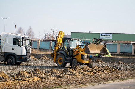 LUTSK, UKRAINE - May 10, 2020：黄色轮式装载机挖掘机和卡车在建筑工地用沙子和砾石工作。