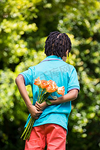 一个孩子把花束藏在背后的后视图