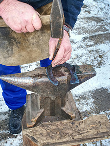 在铁砧上使用穿孔器和锤子
