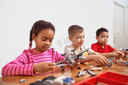 拼搭玩具摄影照片_孩子们使用拼搭套件制作玩具。