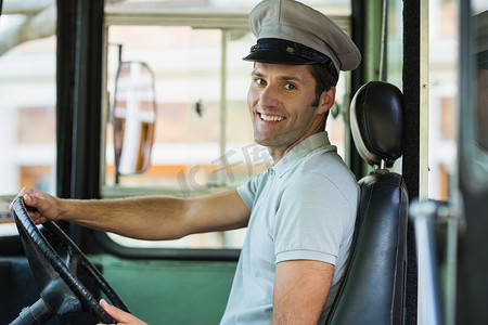 驾驶公共汽车的微笑的公共汽车司机