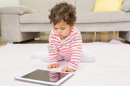 家居女孩摄影照片_可爱的婴儿在地毯上用平板电脑