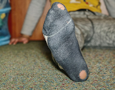 破旧的袜子有洞和鞋跟伸出