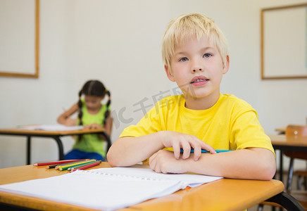 可爱的学生在教室的课桌上涂色
