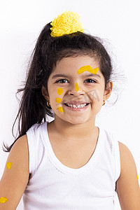 快乐的小女孩，脸上涂着彩绘来庆祝黄色的日子