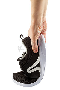 白色背景中突显的人手弯曲轻质黑色透气夏季步行鞋