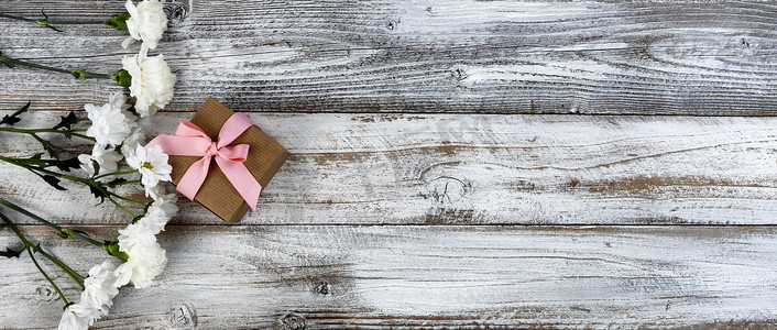 母亲节或情人节假期，质朴木板左侧的真白花和礼盒