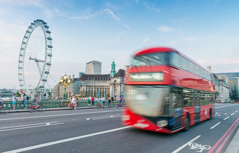 双层红色摄影照片_伦敦-2015 年 6 月 11 日：沿城市街道的红色双层公共汽车