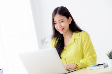 年轻的亚洲女商人在家庭办公室的办公桌上使用笔记本电脑工作，自由职业者在桌上的笔记本上看和打字，女性在线学习的生活方式，商业和教育理念。