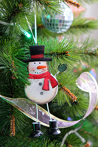 玩具滑稽的铁雪人挂在圣诞树上。