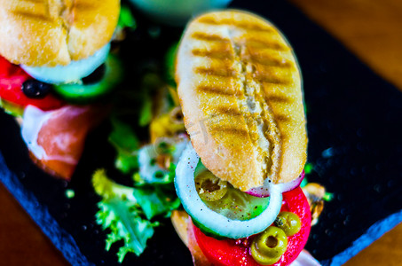 脆骨烤肠摄影照片_迷你烤三明治，包括各种冷肉、奶酪、蘑菇、番茄和鸡蛋，美味健康的小吃