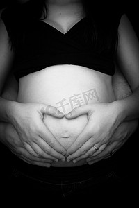 手捂肚子摄影照片_孕妇双手捂着肚子做心形