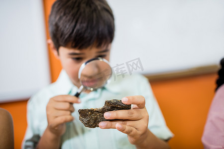 孩子们用放大镜看化石