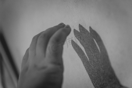 手和她的影子在墙上。