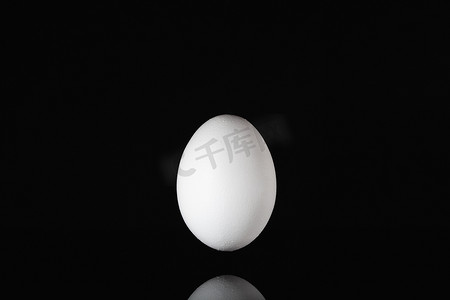 漂浮在黑玻璃桌上的白蛋
