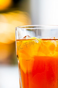 加冰柠檬茶摄影照片_冰茶加柠檬在玻璃杯中作为户外冷饮、夏季鸡尾酒或甜水果苏打饮料、街头食品和餐厅菜单概念