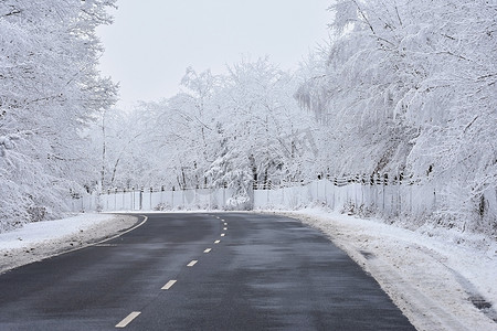 有积雪的风景的空的路。