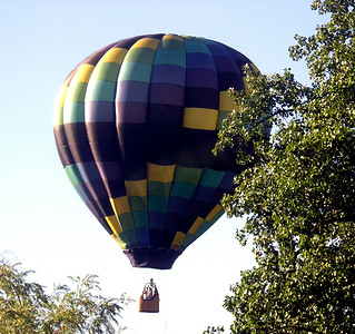 树林间摄影照片_热气球在树林间起飞。