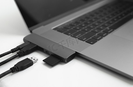 带有 USB C 型适配器的笔记本电脑，带有插入的 USB 电缆和 SD 卡。