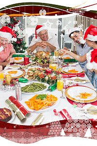 戴着圣诞帽的幸福家庭享受圣诞晚餐
