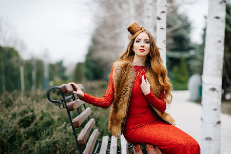 空荡荡的公园长椅上，一头红发，身着鲜红裙子的年轻女孩
