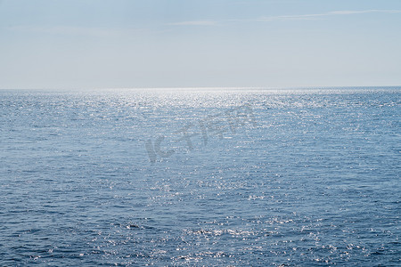 太阳天摄影照片_蓝海或大西洋，小波浪，太阳反射和夏季空间的清澈蓝天 fot 文本