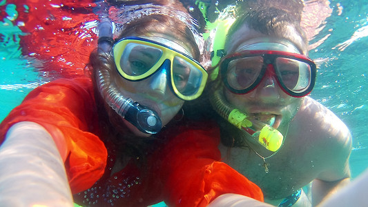 快乐的年轻夫妇在水下自拍，蒙面和浮潜，肖像