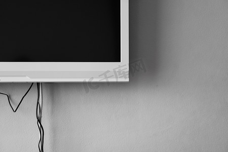 玉雕电视墙摄影照片_液晶或 LED 电视屏幕挂在墙上，房间内配有电视调谐器，用于室内装饰设计。