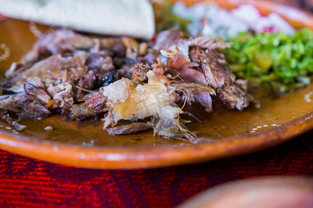 桌布墨西哥摄影照片_彩色桌布上的墨西哥碎羊肉盘