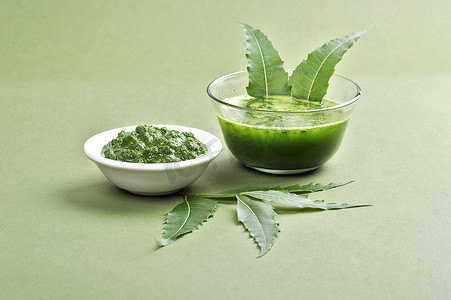 扎基拉姆摄影照片_绿色背景中带叶的药用尼姆叶糊和汁