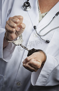 医学伦理摄影照片_戴着实验室外套和听诊器的手铐的医生或护士