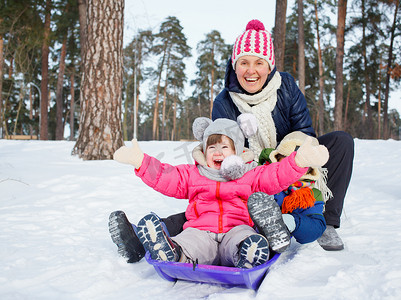 滑稽的家庭在冬天风景雪橇