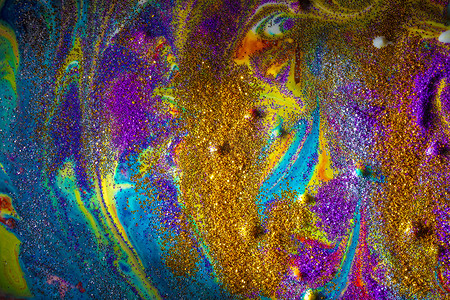 紫色和金色摄影照片_五颜六色的丙烯酸背景，卷发上洒着紫色和金色的火花。