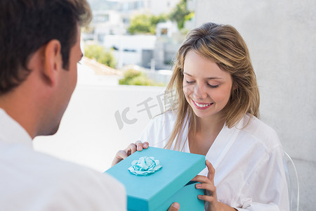 男人给快乐的女人一个礼盒