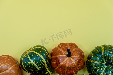 黄色背景上南瓜、葫芦和秋季装饰的秋底边框横幅，带复制空间