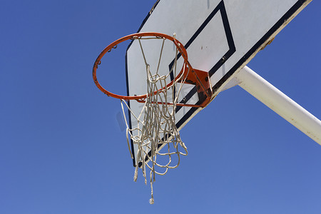 街头篮球摄影照片_蓝天映衬下的户外篮球架 — 街头篮球