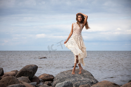 女孩站在海边的石头上