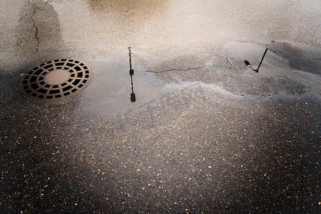 在柏油路背景的浮油排入雨水道