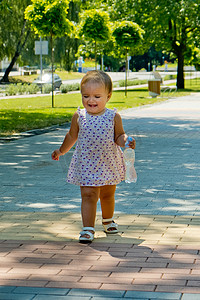 小女孩的哭泣摄影照片_一个小女孩走在人行道上，哭了起来。