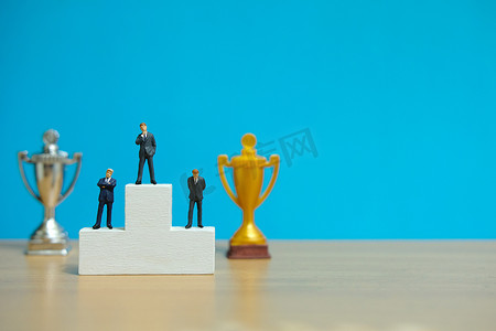 微型商业概念 — 三名商人站在获奖者领奖台上，获得金银奖杯
