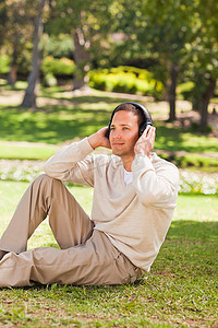 室外音乐摄影照片_男人在公园里听音乐