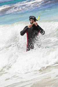 沙滩上带潜水服浮潜面罩脚蹼的男潜水员