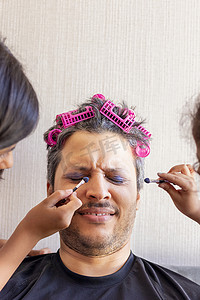 女儿们摄影照片_英俊的父亲正在用女儿们的手化妆