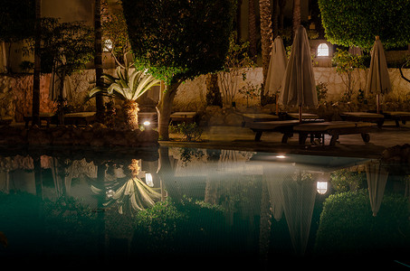 海蓝之谜logo摄影照片_埃及沙姆沙伊赫 — 02 06 2018:晚上在酒店的海蓝宝石泳池里折叠着空木伞