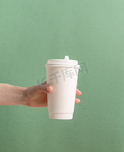 绿色背景中模拟的白色大外卖纸咖啡杯