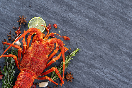煮熟的龙虾，美味的晚餐海鲜餐，黑色石板背景上配有刀叉，餐厅菜单设计，顶视图，头顶