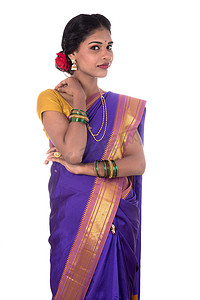 美丽的印度年轻女孩穿着白色背景的传统印度纱丽。